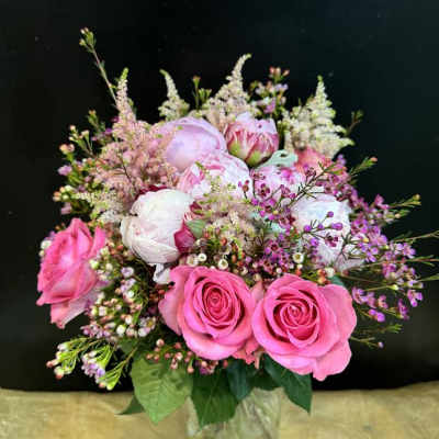 Pink and white bouquet of roses and peonies in a glass vase