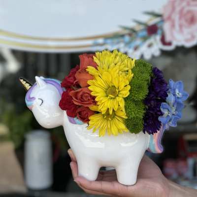 Rainbow flower arrangement in a unicorn-shaped ceramic container