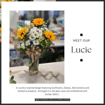 Sunflower and daisy bouquet in a tall glass vase with burlap ribbon