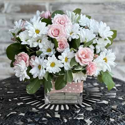 Pink roses and white daisies in a square glass vase