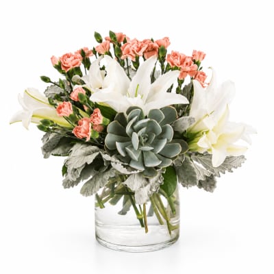Bouquet of white lilies and pink carnations in a clear glass vase