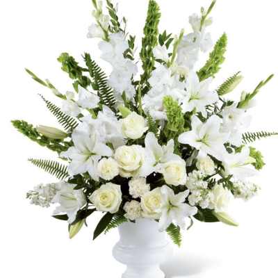 White lilies and roses arranged in a white vase