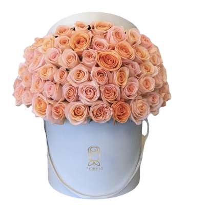 Peach and blush roses arranged in a light blue hatbox