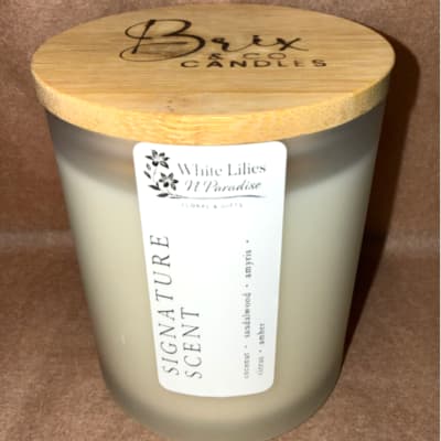 Frosted glass candle jar with a bamboo lid and label