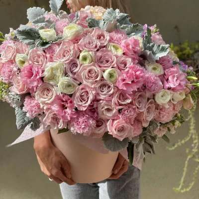 Large pink bouquet of roses and ruffled blooms in a box