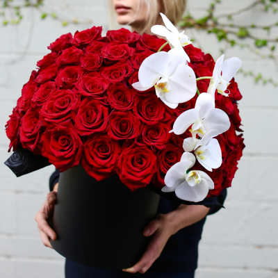 Large bouquet of red roses with white orchids in a black box