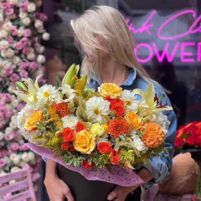 Large mixed bouquet of yellow, orange, and white flowers in a black box