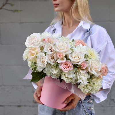 Bouquet of white and blush roses in a pink hatbox