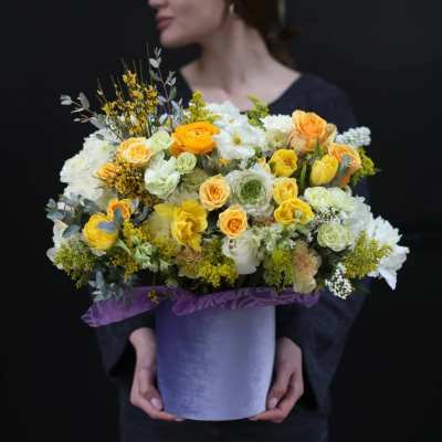 Large yellow and white flower arrangement in a purple hatbox