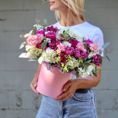 Woman holding a pink box of pink and white flowers