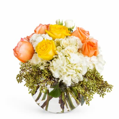 Bouquet of yellow, orange, and white roses in a clear glass vase