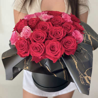 Bouquet of red and pink roses wrapped in black paper