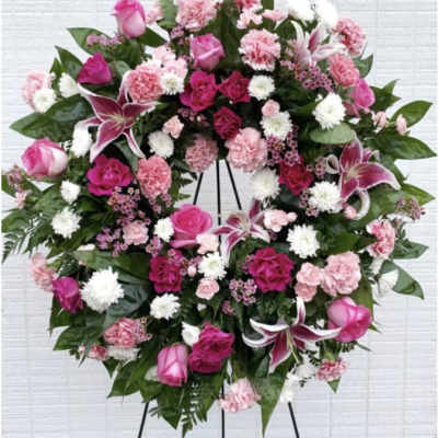 Pink and white floral wreath on a black easel