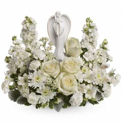 White floral arrangement with roses and a praying angel figurine