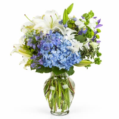 Blue and white mixed bouquet in a clear glass vase