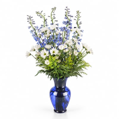 Blue and white flowers arranged in a cobalt vase