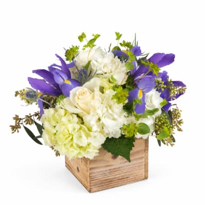 Purple and white floral arrangement in a wooden box