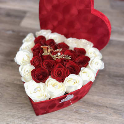 Heart-shaped red box filled with red and white roses
