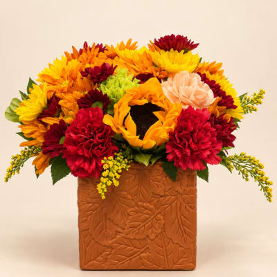 Colorful bouquet of sunflowers and carnations in a textured brown vase