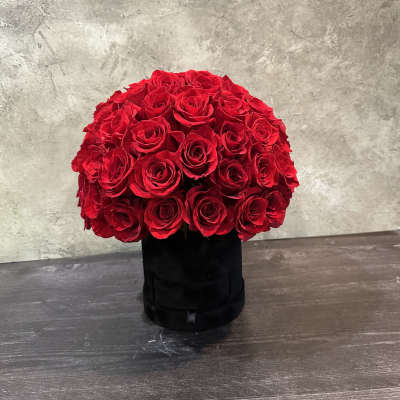 Round bouquet of red roses in a black box