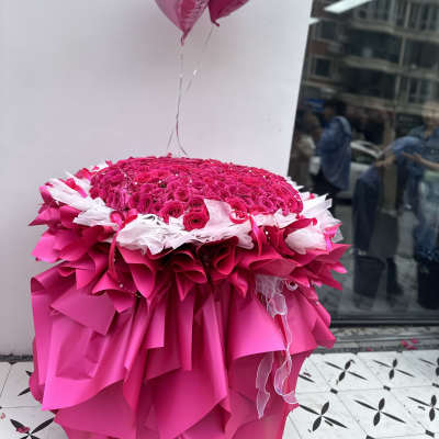 Large pink rose arrangement with heart balloons and layered pink wrapping