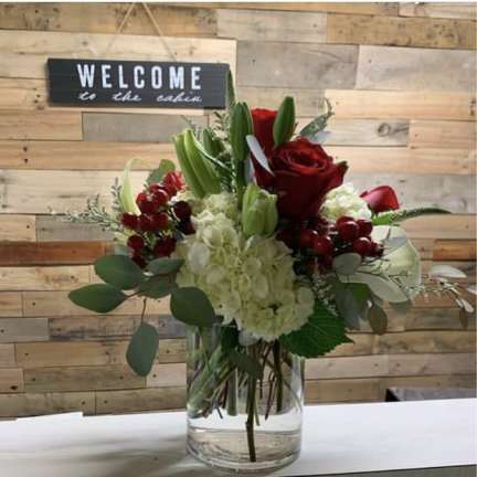 Red roses and white hydrangeas in a clear glass vase
