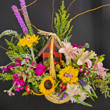 Basket arrangement with sunflowers, pink lilies, and purple flowers