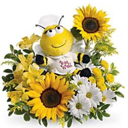 Bee plush surrounded by sunflowers and white daisies