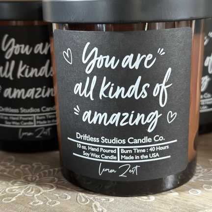 Black jar candle with a label reading "You are all kinds of amazing"