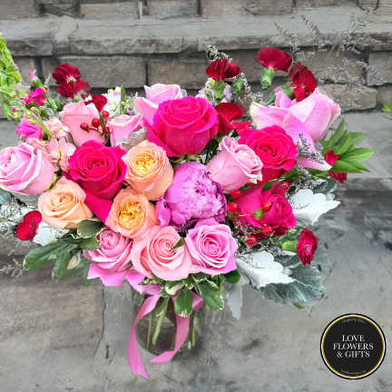 Bouquet of pink and red roses with carnations in a glass vase