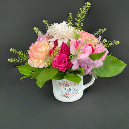 Pink and white flower arrangement in a decorative mug