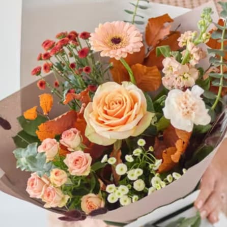 Bouquet of peach and pink flowers wrapped in paper