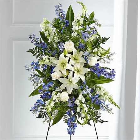 Tall white and blue floral standing spray on an easel