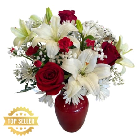 Red roses and white lilies arranged in a red vase