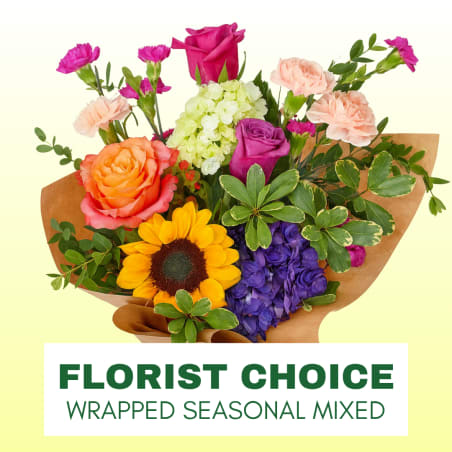 Mixed bouquet with roses, sunflower, hydrangea, and carnations wrapped in brown paper