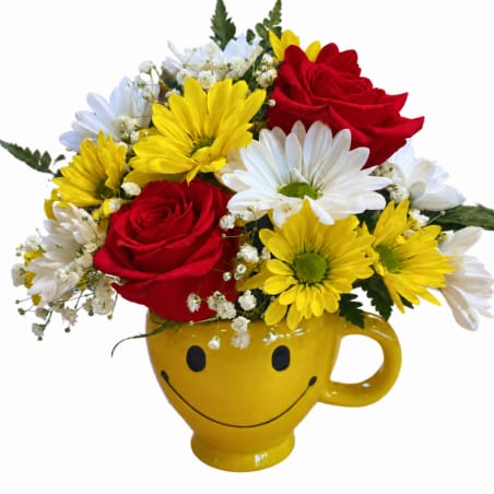 Red roses and yellow-white daisies in a yellow smiley-face mug