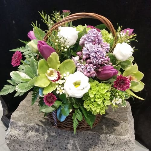 Mixed flower basket with purple, white, and green blooms