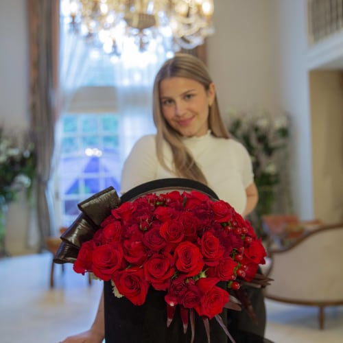 Large bouquet of red roses in a black hat box