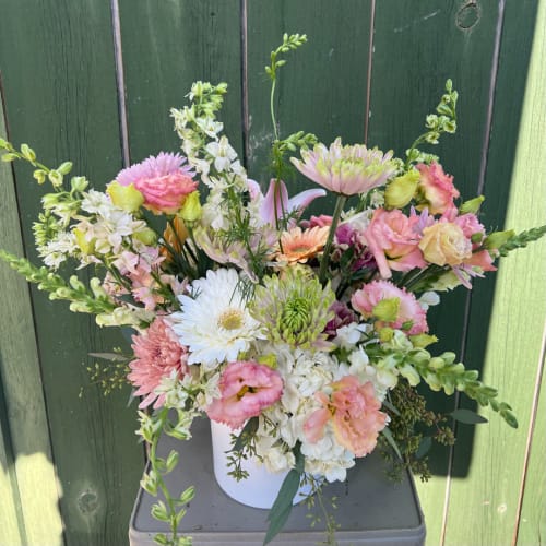 Mixed pastel bouquet in a white vase with daisies, roses, and chrysanthemums
