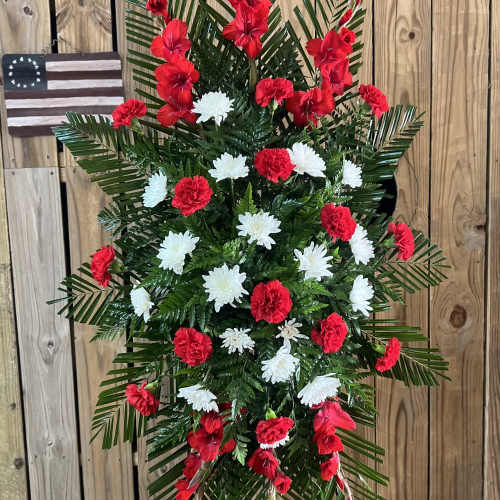 Standing floral spray with red and white flowers on a wire easel