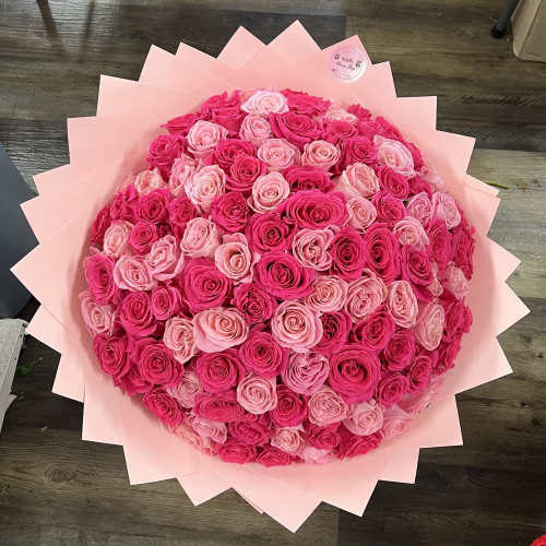 Large bouquet of pink and hot pink roses wrapped in pale pink paper