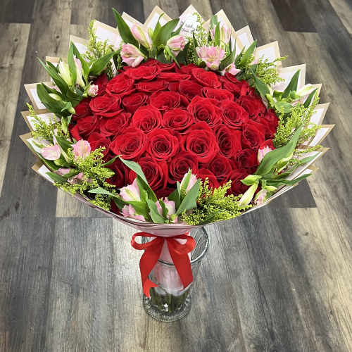 Bouquet of red roses with pink lilies in a glass vase