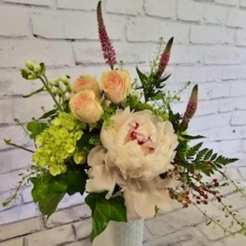 Bouquet of pale peach and white flowers in a white vase