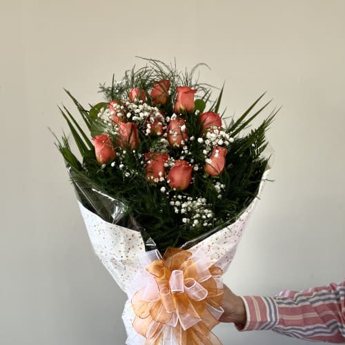 Bouquet of coral roses with baby's breath and a large ribbon