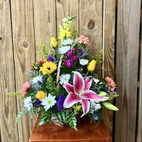 Mixed flower basket with pink lily, yellow roses, and white daisies
