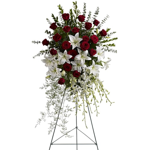 Standing floral spray with red roses and white lilies on an easel