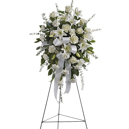 White funeral spray on a standing easel with ribbon
