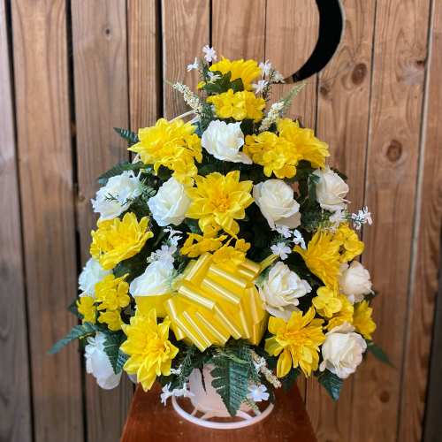 Tall arrangement of yellow and white silk flowers with a yellow striped bow in a white pot.