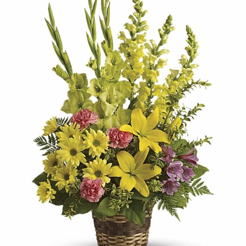 Yellow and pink flowers arranged in a woven basket