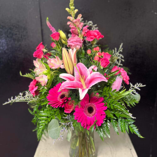Pink lilies and gerbera daisies in a glass vase